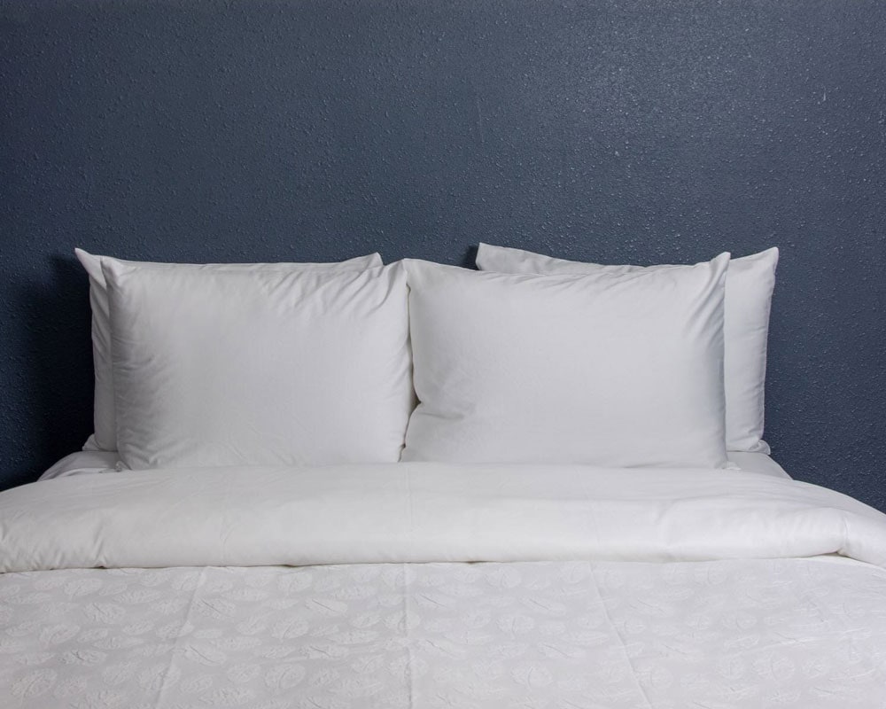 Newly renovated room with a queen bed and white bedding at Kendall Mountain Lodge